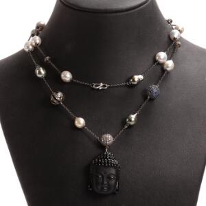 Halskæde af oxideret sølv og 14 kt. hvidguld prydet med sort jadevedhæng i form af buddha hoved, tahiti perler, safirer og diamanter. L. ca. 81 cm.