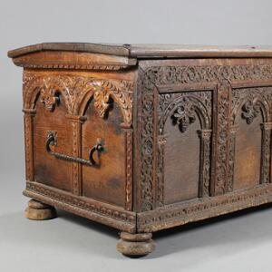 Fladlåget renaissance kiste af egetræ, prydet med skæringer, i sidderne bæregreb af jern. H. 76. B. 182. D. 80.