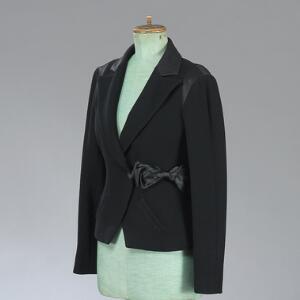 Chanel Sort jakke af uldbouclé med for, besætning og sløjfe af sort silke. L. ca. 60 cm. Str. 38.