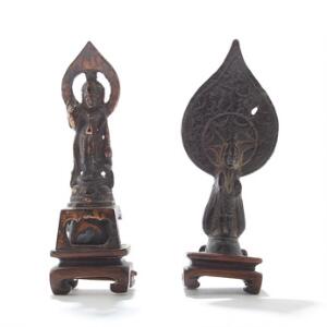 To orientalske miniature gudefigurer af patineret bronze, på stand af udskåret træ. Begge med inskriptioner. 17.-18. årh. H. inkl. baser 11. 2
