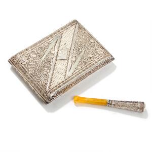 Filigran cigaretæske og cigaretrør af sølv, dekoreret med blomstrende grene samt graveret med initial. 20. årh. Vægt ca. 125 gr. L. 10,5 og 8. 2