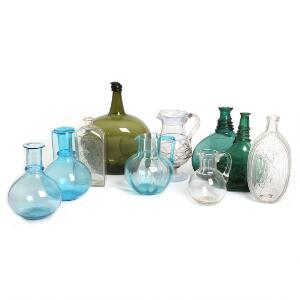 En samling flasker, kander m.m. af klart og farvet glas. 18.-19. årh. H. 16-29. 10