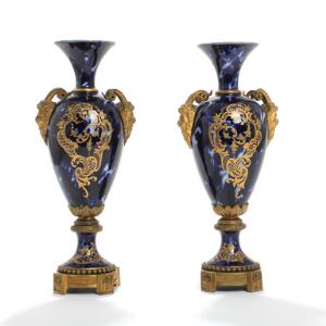 Et par franske prydvaser af porcelæn, dekorerede med blåmarmoreret glasur og ornamentik, fodstykker og hanke af bronze. 19. årh. H. 37. 2