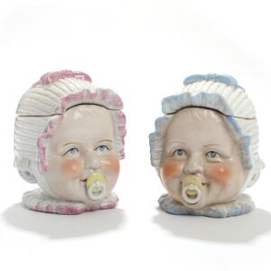To engelske lågkrukker af porcelæn i form af babyhoveder, dekorerede i farver. 20. årh. H. 14. 2