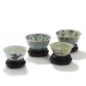 Fire kinesiske risskåle af porcelæn på baser af udskåret træ, dekoreret i blåt med drager. 18.-19. årh. Skåle H. 5,5-7. Diam. 12-15. 4