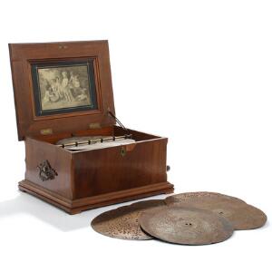 Tysk spillemaskine i kasse af nøddetræ, 15 tilhørende plader medfølger. 19. årh. Kasse H. 23. L. 50. B. 38.