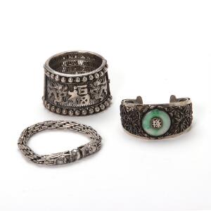 Tre smykker af sølv, bestående af to armringe med gennembrudt dekoration, en prydet med jade, et armbånd med to drager der bider i kugle. Centralasien. 3
