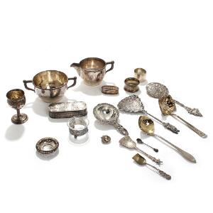 En samling sølv, bestående af bæger, etui m.m. Vægt ca. 635 gr. Samt et par lysestager af sølv. Udfyldte. 19.-20. årh. Lysestager H. 4,5. 18
