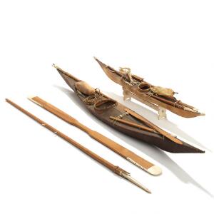 To modeller af grønlandske kajakker af træ og skind monteret med pagajer og fangstredskaber af træ og ben. 20. årh. L. 62-79. 4