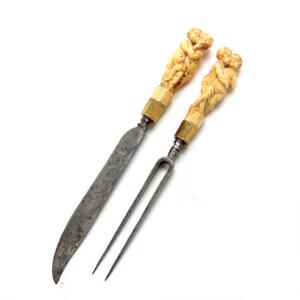 Rejsebestik bestående af kniv og gaffel med greb af elfenben i form af et par putti i omfavnelse. 17. årh. L. 17-18 cm.