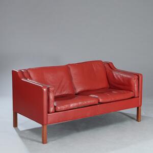 Børge Mogensen Fritstående to-pers. sofa opsat på ben af mahogni. Sider, ryg samt løse hynder betrukket med rødt farvet skind. Model 2212. L. 157.