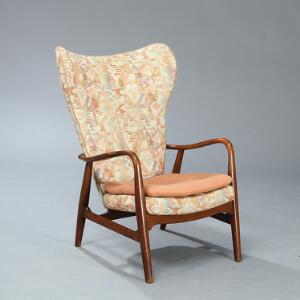 Arne Vodder Lænestol af bejdset kirsebær. Sider og dybthæftet ryg betrukket med mønstret stof, løs sædehynde betrukket med rosa stof.