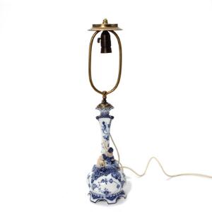 Arnold Krog Musselmalet helblonde, lampe af porcelæn, dekoreret i underglasur blå, prydet med faune og pige samt maskaroner. Royal Copenhagen. H. 35 cm.