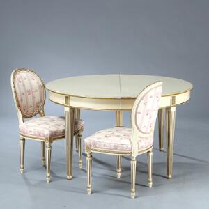 Spisestue af hvidmalet og guldstafferet træ, bestårnde af otte medaljonstole og rundt bord med udtræk og to plader samt et par stole. Louis XVI form, 20. årh.