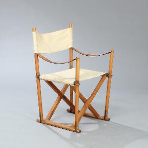 Mogens Koch Instruktørstolen. Foldestol af patineret bøg. Sæde samt ryg af lyst kanvas. Armstropper af patineret kernelæder.