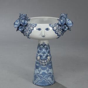 Bjørn Wiinblad Kolossal opsats af lertøj, modelleret i form af kvindeskikkelse omgivet af blomster. Dekoreret med blå glasur på lysegrå baggrund. H. 63.