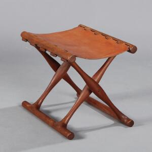 Poul Hundevad Guldhøj stol. Foldeskammel af massivt teaktræ med sæde af cognacfarvet kernelæder. Udført hos Poul Hundevad.