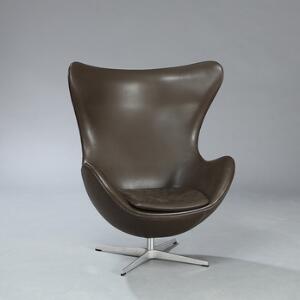 Arne Jacobsen Ægget. Hvilestol med vippefunktion, stamme af stål og firpas fod af aluminium. Betrukket med brunt farvet skind.