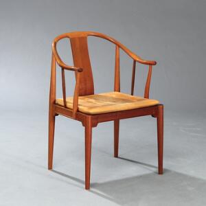 Hans J. Wegner Kinastol. Armstol med stel af mahogni. Løs sædehynde betrukket med patineret dybthæftet naturskind. Udført hos Fritz Hansen.