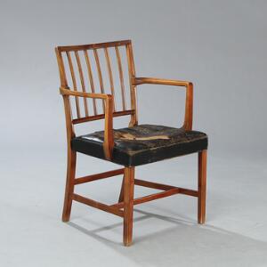 Jacob Kjær Armstol med profileret stel af mahogni. Sæde betrukket med sort skind. Udført hos snedkermester Jacob Kjær.