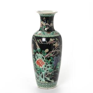 Kinesisk famille noire balusterformet vase af porcelæn, dekoreret i farver med magnolie gren og klippe på sort grund. 19. årh. H. 45 cm.