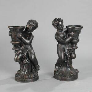 Et par blomsteropsatse af bronzeret støbejern i form af putti med krukker. 20.-21. årh. H. 76 og 77. 2