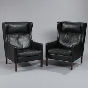 Dansk møbeldesign Et par øreklapstole med ben af mørkbejdset træ, sæde, ryg og hynder med sort skind. 2