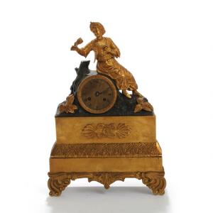Fransk kaminur af delvis patineret bronze, urhus prydet med orientalsk herre siddende ved en træstub. 19. årh. H. 40,5.