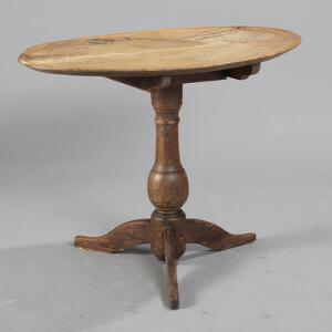 Ovalt tilt-top table af egetræ på tre-pas fod med balusterformet stamme. 18.-19. årh. H. 64. L. 87. B. 56.