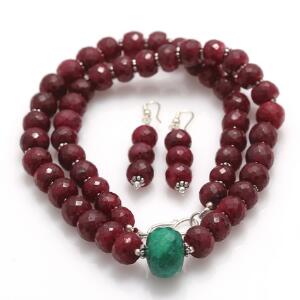 Rubinsmykkesæt bestående af et par ørestikker og en halskæde, begge prydet med perler af facetsleben rubin, halskæde desuden med større smaragd.