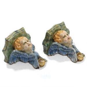 Et par italienske vægkonsoller af glaseret terrakotta, modelleret med putti. Barokform. Ca. 1900. H. 11. B. 16. D. 17. 2