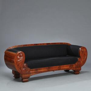 Senempire sofa af mahogny, svungne sider udskåret med delfiner. 19. årh.s første halvdel. L. 210.