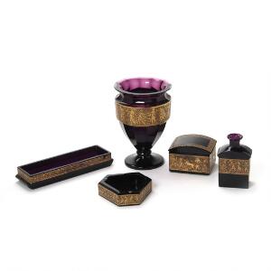Samling amatystfarvet Moser glas bestående af vase, flaske, askebæger, penneholder mm dekorerede med forgyldt figur- og bladfrise. H. 20 cm. L. 22,5 cm. 5