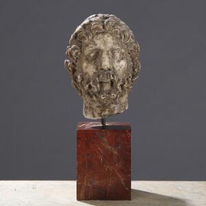 Grand Tour buste af marmor i form af klassisk mandshoved bærende laurbærkrans. Sokkel af rødbroget marmor. Udført i Italien efter romersk forbillede. 19. årh.
