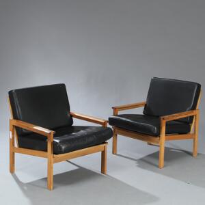 Illum Wikkelsø Capella. Et par lænestole med stel af patineret eg. Løse hynder i sæde og ryg betrukket med sort skind. 2