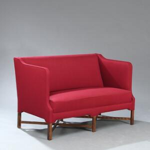 Kaare Klint Fritstående to-personers sofa med profileret krydsbenstel af mørkbejdset eg. Sider, sæde og ryg betrukket med rød uld. L. 134.