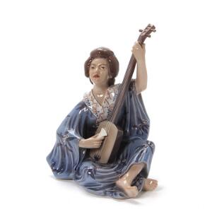 Figur af porcelæn, dekoreret i underglasur i form af Geishia spiller instrument. 1155. Dahl-Jensen. H. 23 cm.