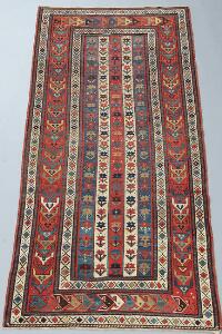 Et antikt Gendje tæppe, Kaukasus. Design med vertikale striber med stiliserede blomster. Ca. 1900. 232 x 109.