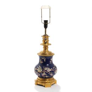 Kinesisk bordlampe af porcelæn med top og base af forgyldt bronze, rigt støbt med bladguirlander og ornamentik. 19.-20. årh. H. inkl. mont. 65.