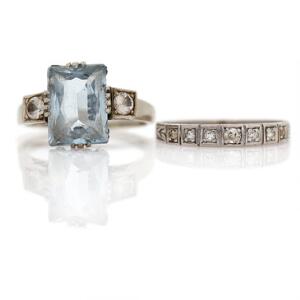 To ringe af henholdsvis 14 og 18 kt. hvidguld prydet med henholdsvis enkeltslebne diamanter og blå og hvide sten. Str. 50 og 52.