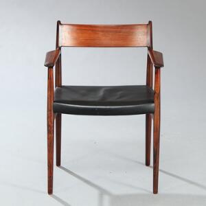 Arne Vodder Armstol af palisander, opsat på tilspidsende ben. Sæde betrukket med sort skind. Model 404. Udført hos Sibast.
