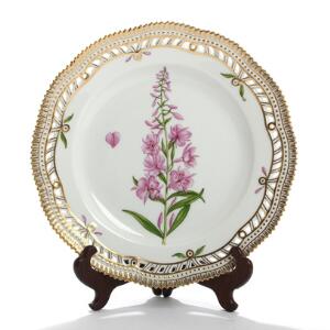 Flora Danica. Gennembrudt tallerken af porcelæn, Kgl. P., dekoreret i farver og guld med blomster. Nr. 3553. Diam. 25,5.