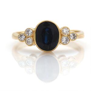 Safir- og diamantring af 18 kt. guld prydet med facetslebet safir flankeret af brillantslebne diamanter. Str. 48.