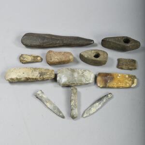 En samling oldsager bestående af 7 økser, 2 dolke, 1 glimmersten, 1 økseformet sten og et sykke forstenet træ.  12.