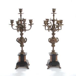 Et par kandelabre af patineret bronze, rigt støbt med ornamentik, på baser af marmor. Ca. 1890. H. 57,5. 2