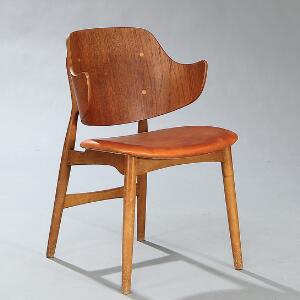 Jens Hjorth Armstol med ryg af formbøjet lamineret teak, stel af eg. Sæde betrukket med brunt skind. Udført hos Randers stolefabrik, 1954.