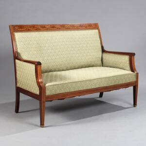 Fritstående to-personers sofa af mahogni, rigt prydet med intarsia i form af blomsterguirlander. Empireform. Ca. 1910. H. 98. B. 132. D. 74.