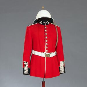 Engelsk Elisabeth II uniformsjakke for menig af The Grenadier Guards med bælte og medfølgende militær tropehjelm.