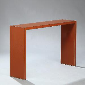 Moderne konsol med overflade af orange-brun, krakeleret lak og kantlister af poleret messing. H. 75. L. 120. D. 30.
