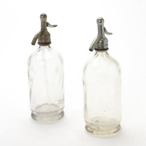 To sifonflasker fra Carlsberg og Tuborg bryggerierne, begge med haner af forniklet jern. Fremstillet på Kastrup Glasværk, hhv. 1926 og 1928. H. 31. og 32. 2